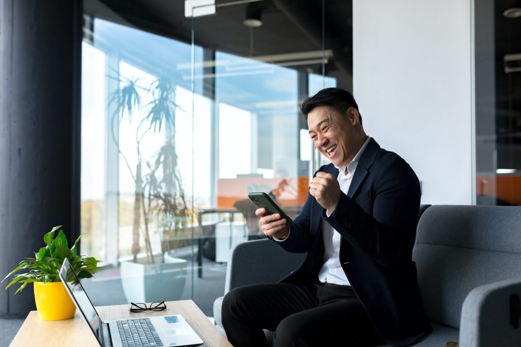Successful business man, rejoices in victory and successful sales contract, smiles looks at camera